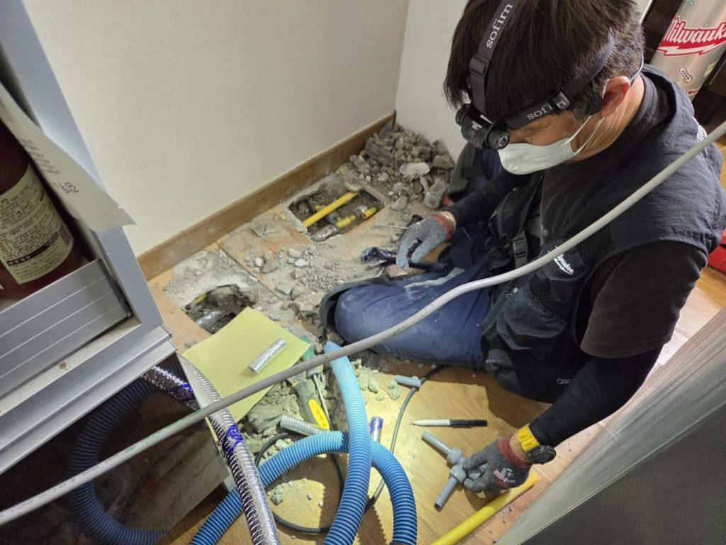 누수 종결 작업 중인 전문 수리공 모습, 누수 수리 및 배관복구 서비스 제공.