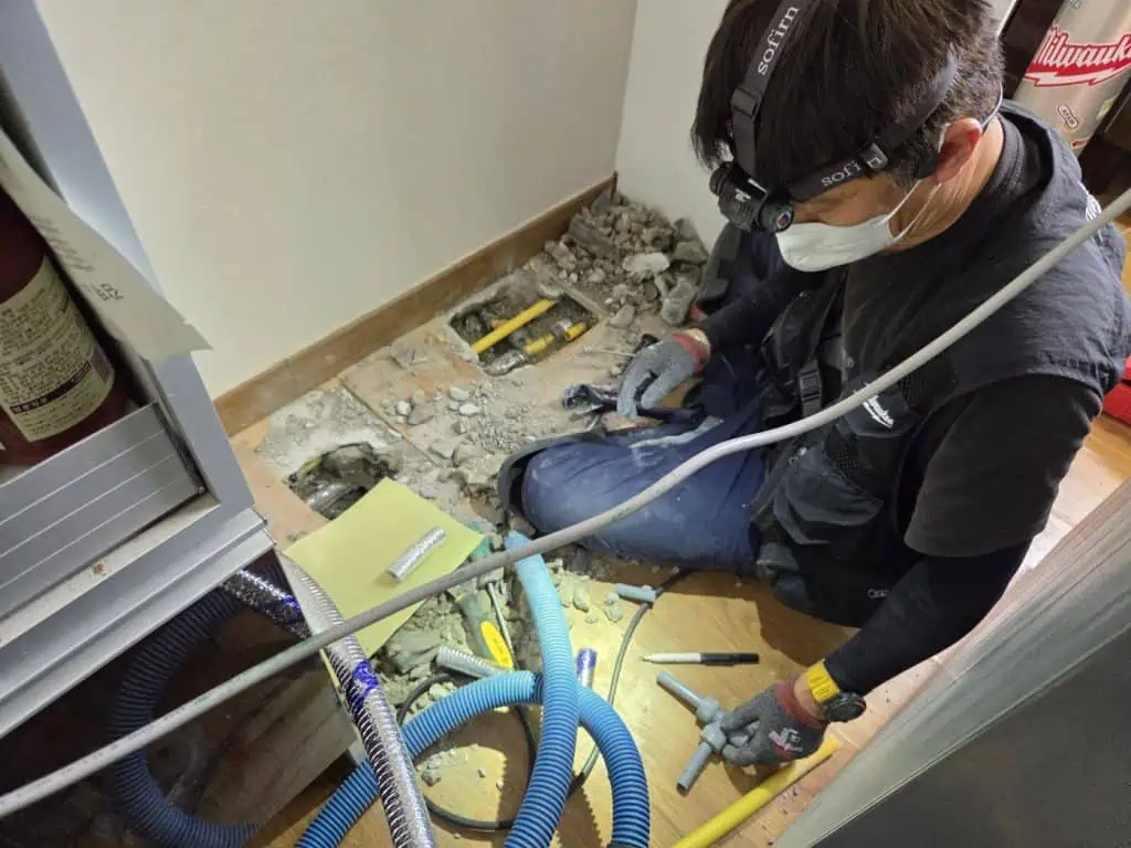 누수 종결 작업 중인 전문 수리공 모습, 누수 수리 및 배관복구 서비스 제공.