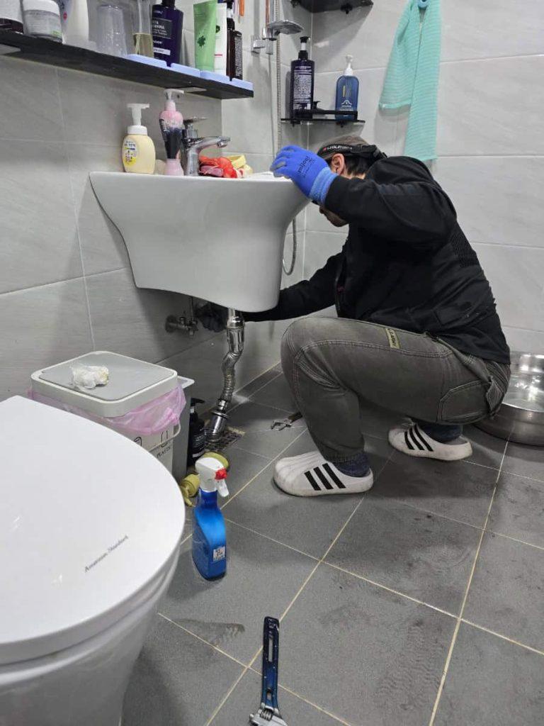 누수수리 전문가가 싱크대 배관 누수 수리 모습.