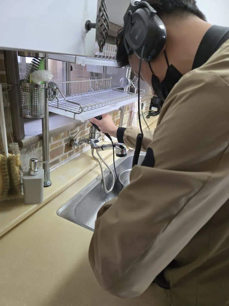 누수탐지 전문가가 수도 누수 원인을 정밀 검사하는 모습.